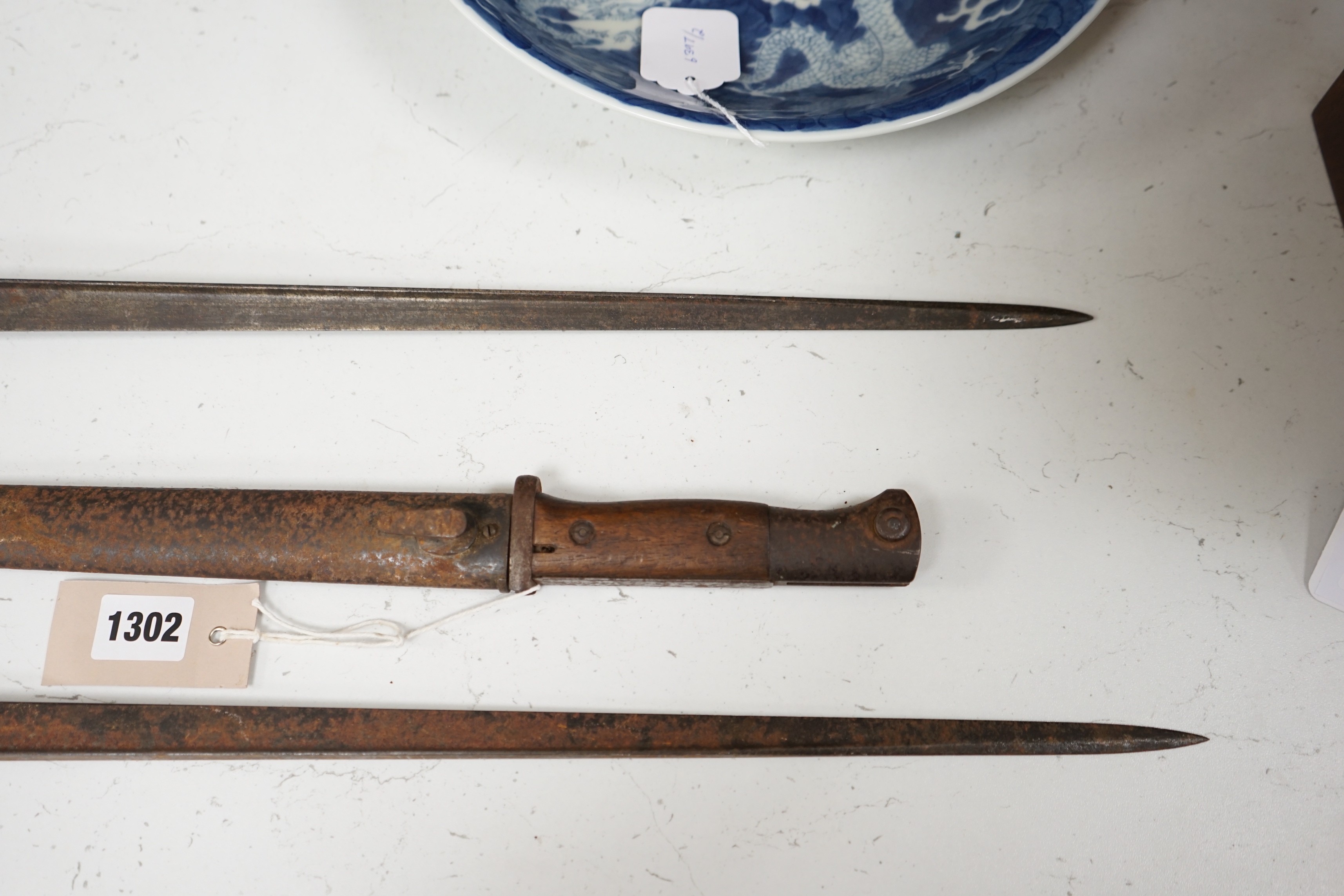 A WWI German bayonet and sheath and two other bayonets